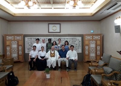 Group in two rows (standing and sitting) in a large room.