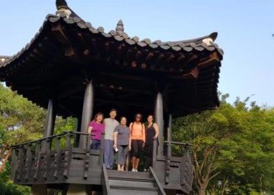 Small group of people standing under a black Korean pavilion