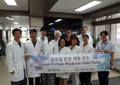 Group of doctors holding "Global Korean Medicine Field Study" sign