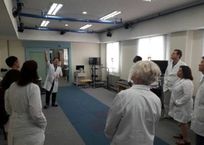 Male doctor pointing to something on the ceiling while small group of doctors surround