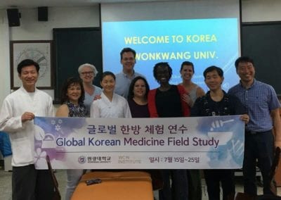 Group of doctors and others holding "Global Korean Medicine Field Study" sign