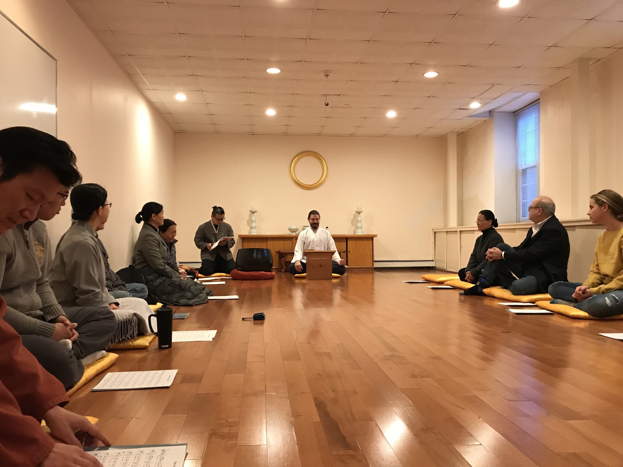 a group of people are sitting on the floor in a room | Won Institute Meditation Session