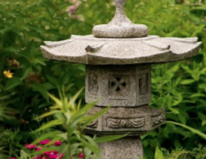 a stone lantern is sitting in the middle of a garden
