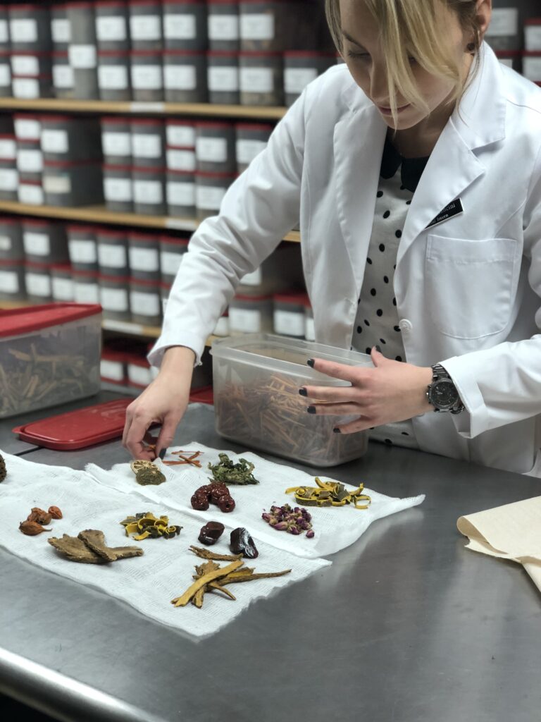 A woman in a lab coat is preparing a sample.