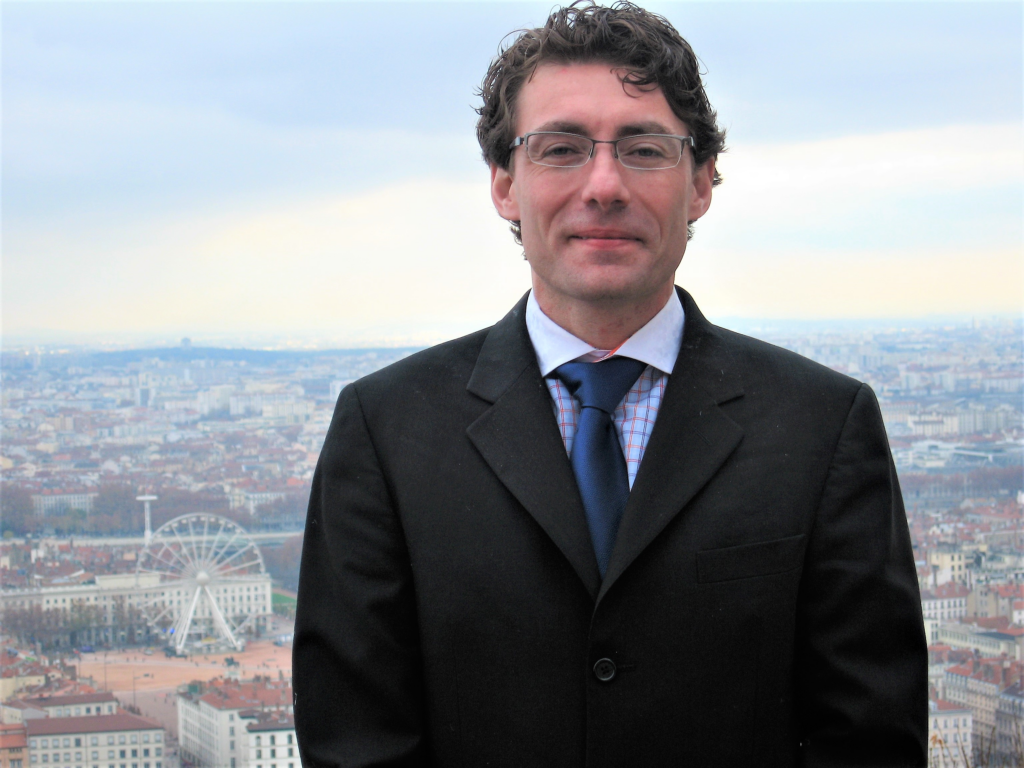 A man in a suit standing in front of a city.